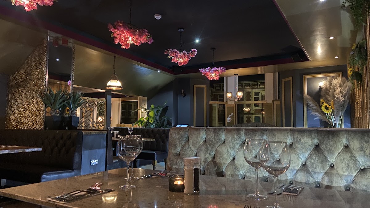 The dining room at The Glass House, with velvet booths, marble tables and blossom chandeliers