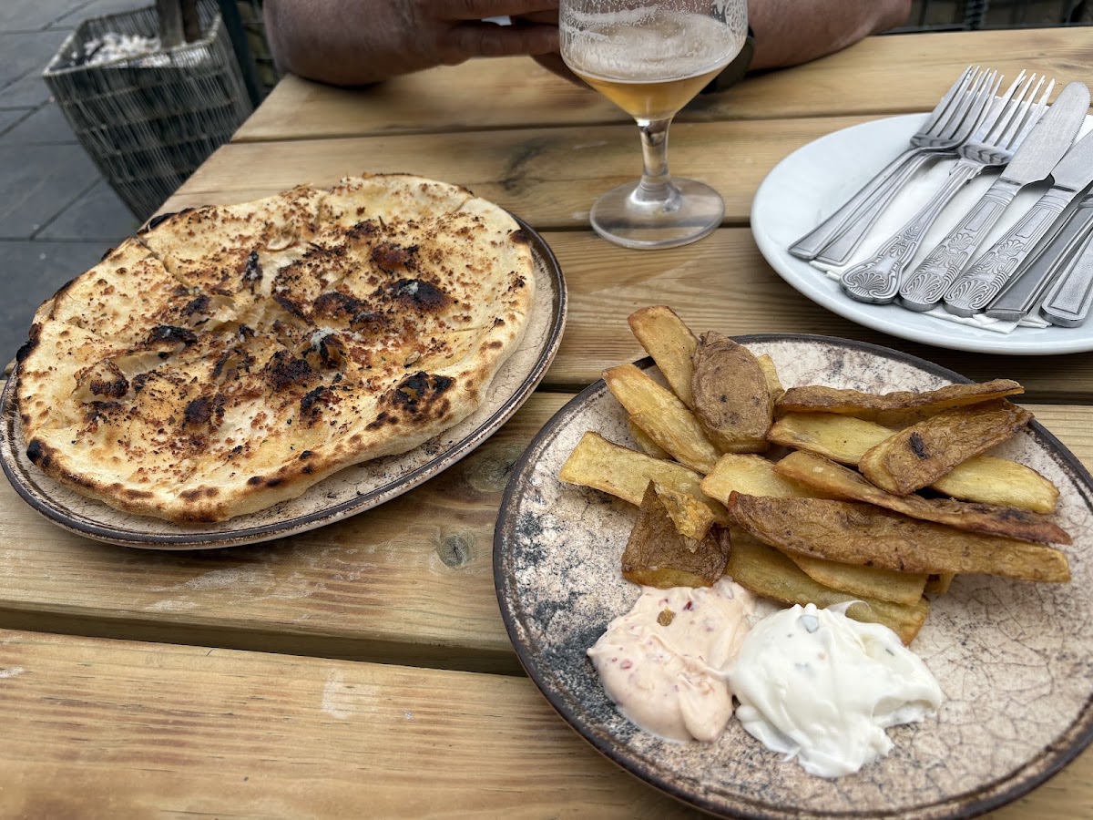 Flatbread and hand cut chips with dips on an outdoor table