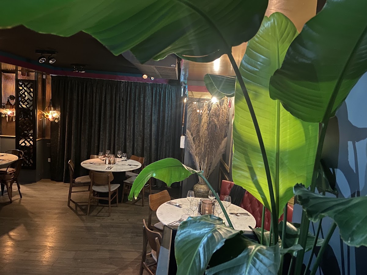 The dining room, with greenery, marble tables and leather booths