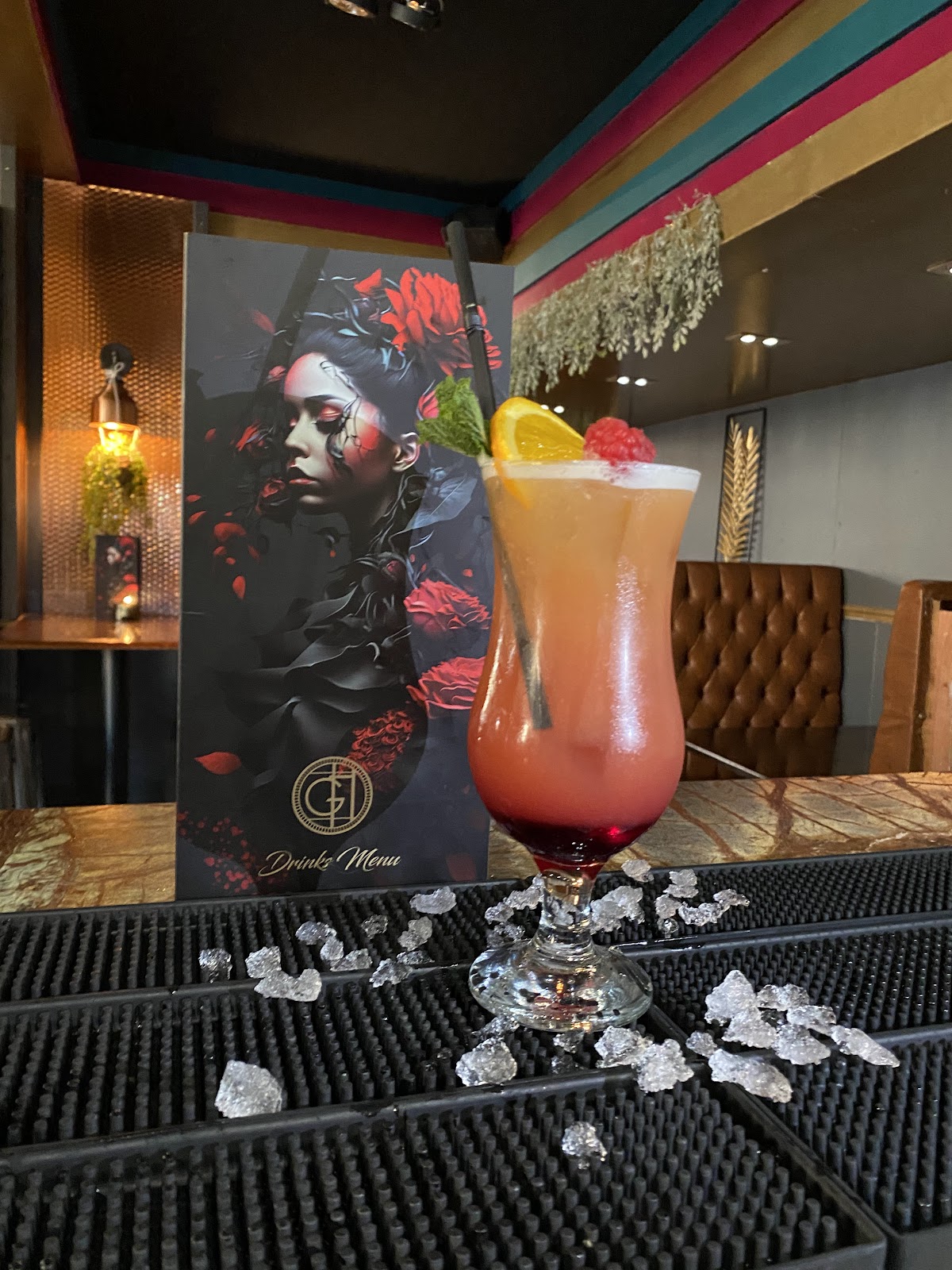 A cocktail on the bar beside The Glass House drinks menu