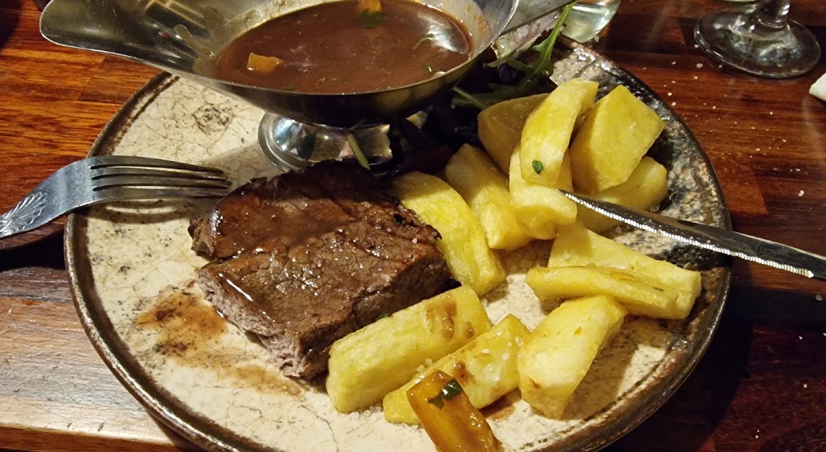 Steak with hand cut chips and a jug of peppercorn sauce
